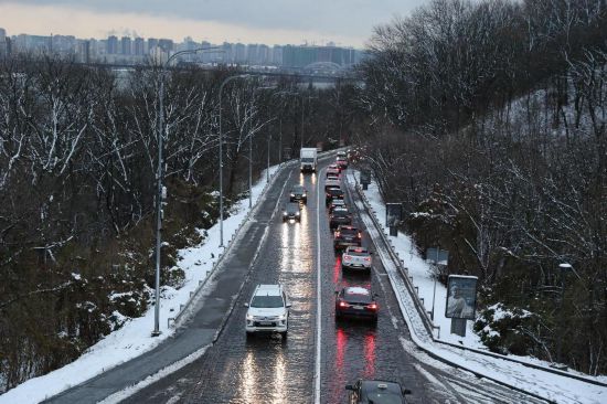 这是2024年11月21日拍摄的白雪映衬下的乌克兰首都基辅右岸沿河公路。新华社记者李东旭摄